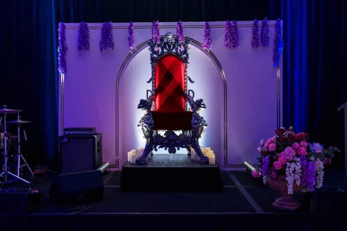 Decorative throne chair displayed on stage with floral styling and dramatic lighting. Throne Stage Feature Installation