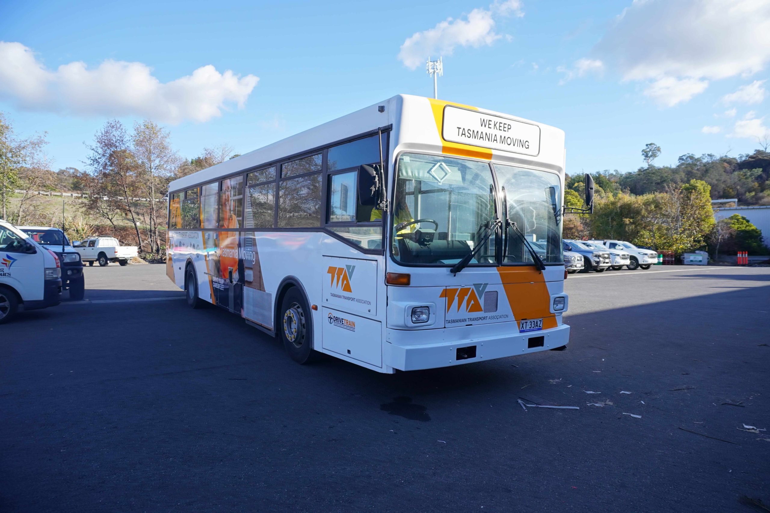 TTA Bus Wrap Tasmanian Transport Association bus wrap installed by Flying Colours Group featuring bold orange and white branding.