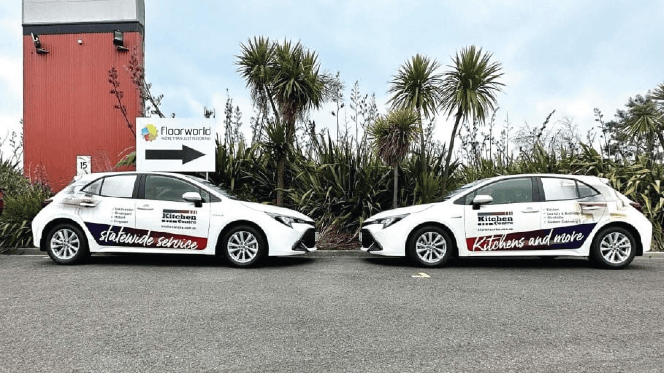 Kitchen Centre Fleet Vehicle Signage Two white Kitchen Centre hatchbacks with coordinated purple and red signage displaying service locations and business messaging.