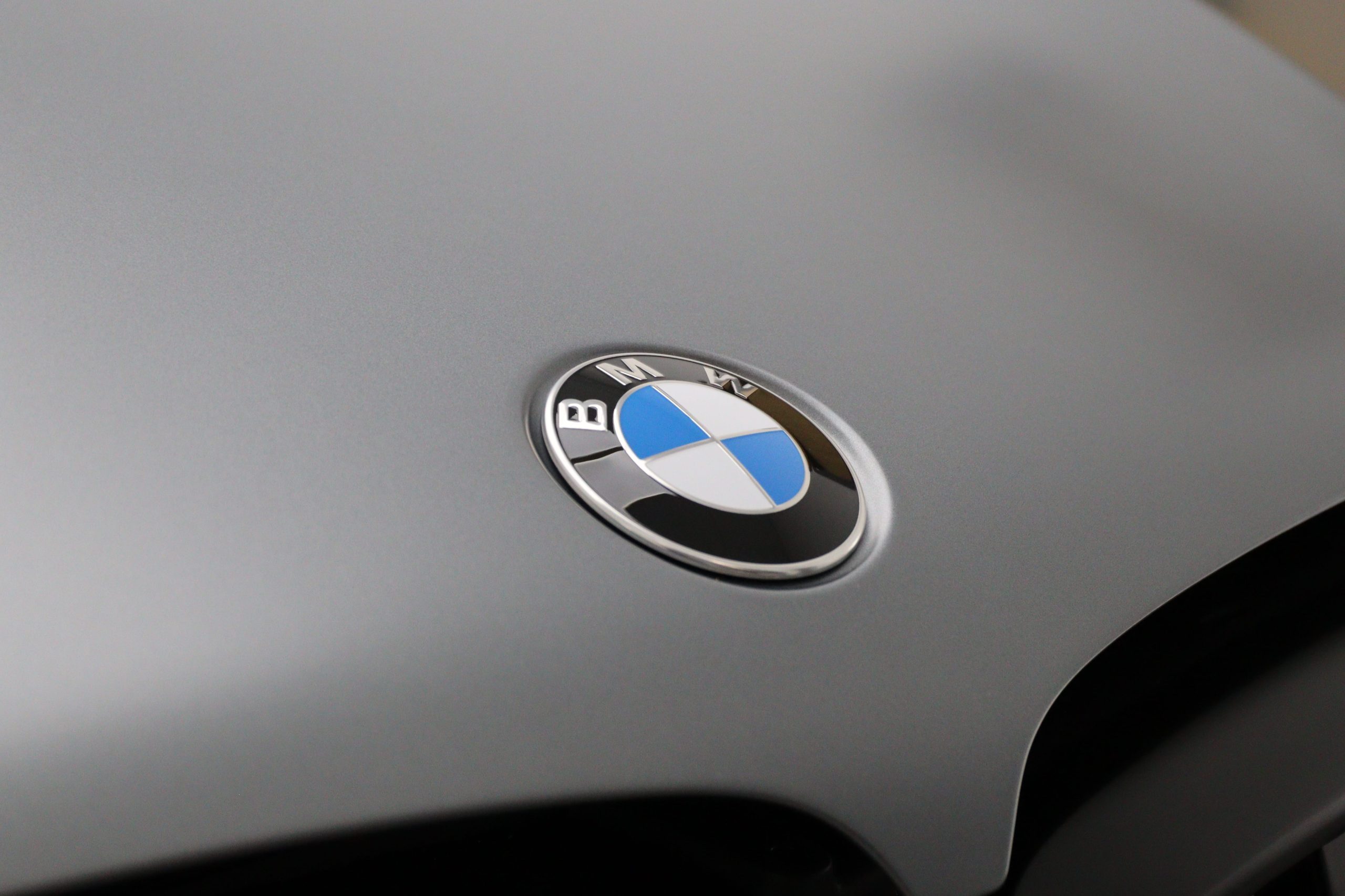 BMW Bonnet – Finished Paintwork Detail Close-up of a grey BMW bonnet showing the badge and smooth paint finish above the front grille.